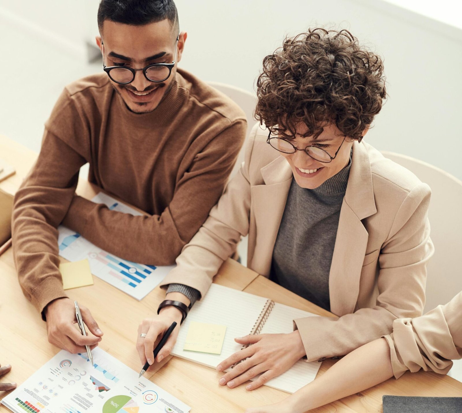 A diverse team of professionals collaborating over charts and graphs during a business meeting.